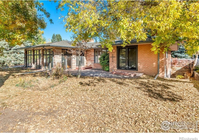 view of front of property with a patio area and brick siding