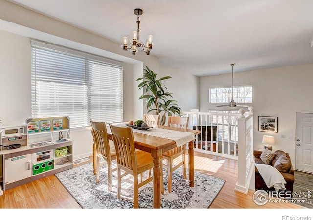 dining room featuring light wood-style floors, baseboards, and an inviting chandelier