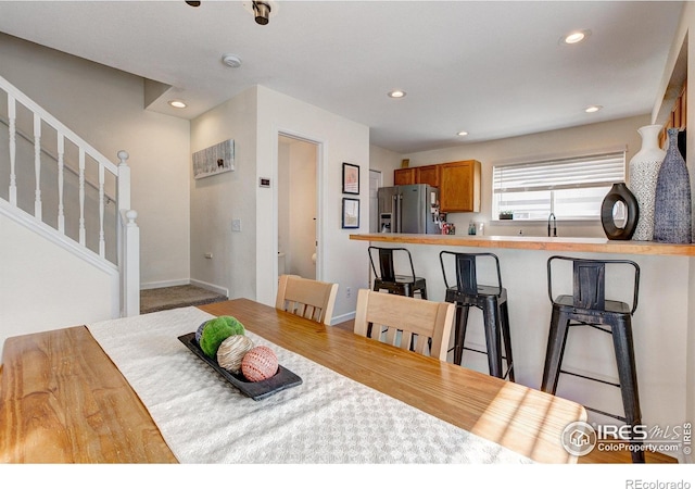 dining room featuring baseboards, stairway, and recessed lighting