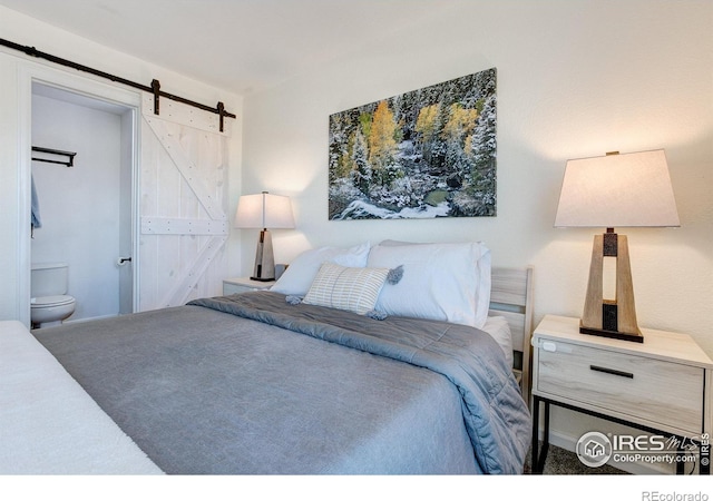 carpeted bedroom with a barn door and ensuite bathroom