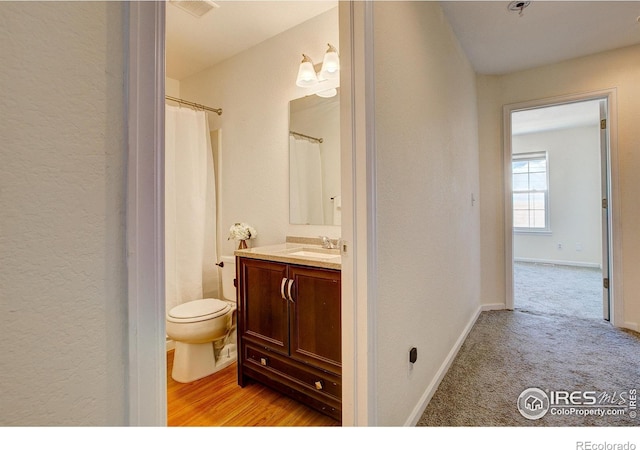 bathroom with baseboards, vanity, and toilet