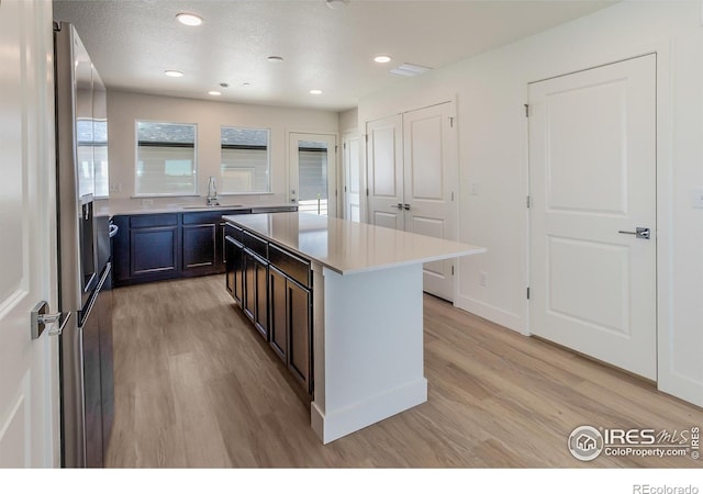 3282 Crusader St, Fort Collins, CO 80524 - kitchen featuring a sink, light wood finished floors, light countertops, a kitchen island, and recessed lighting