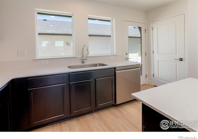 3282 Crusader St, Fort Collins, CO 80524 - kitchen with stainless steel dishwasher, a sink, light wood finished floors, and light countertops