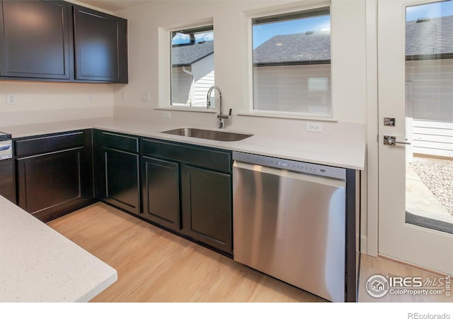 3282 Crusader St, Fort Collins, CO 80524 - kitchen with stainless steel dishwasher, a sink, light wood finished floors, and light countertops