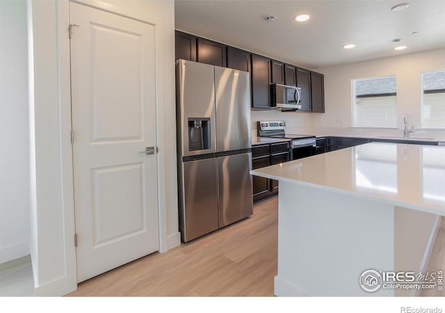 3282 Crusader St, Fort Collins, CO 80524 - kitchen featuring stainless steel appliances, a sink, light wood-style floors, recessed lighting, and dark brown cabinets