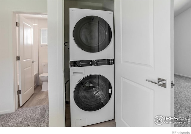 3282 Crusader St, Fort Collins, CO 80524 - laundry room with estacked washer and dryer, carpet floors, and wood finished floors