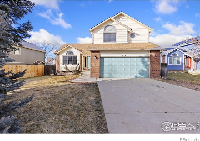 traditional home with concrete driveway, brick siding, fence, and an attached garage