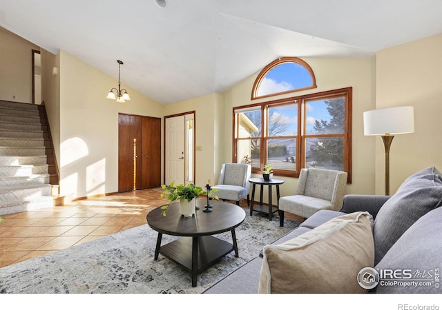 tiled living area featuring vaulted ceiling, stairway, and a notable chandelier