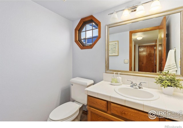 half bathroom with vanity and toilet