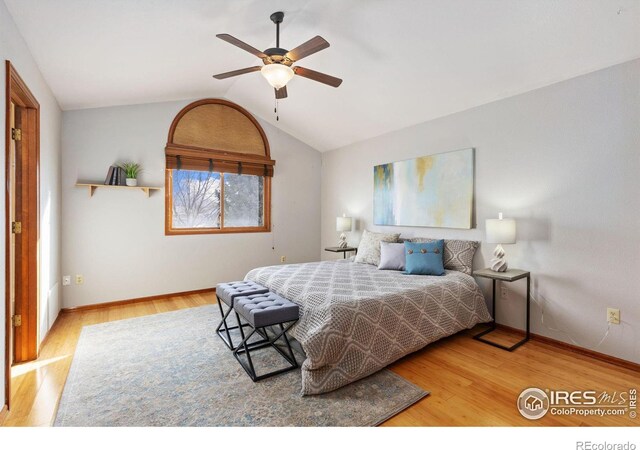 bedroom featuring lofted ceiling, a ceiling fan, baseboards, and wood finished floors