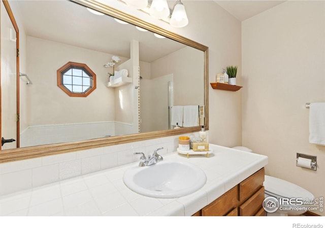 bathroom with a shower with door, vanity, and toilet