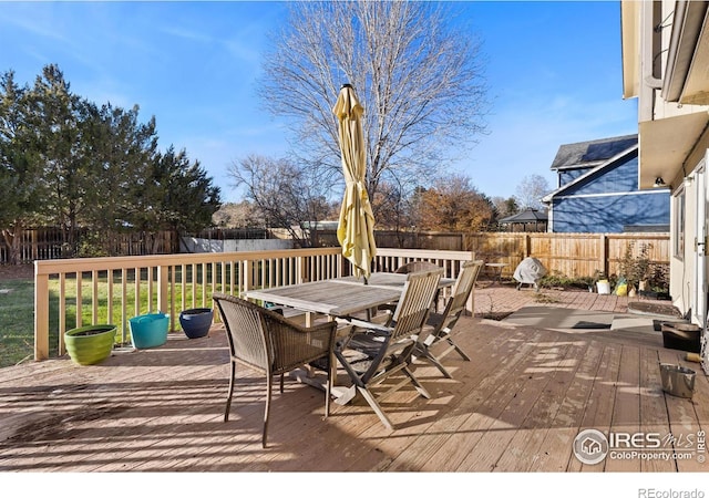 wooden deck featuring outdoor dining space and a fenced backyard