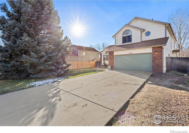 view of front of home with a garage, driveway, brick siding, and fence