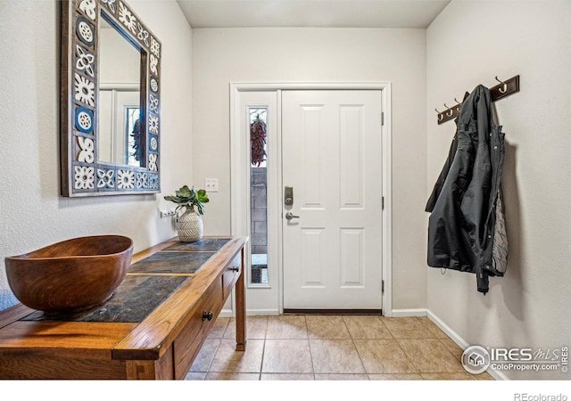 entrance foyer with light tile patterned floors and baseboards