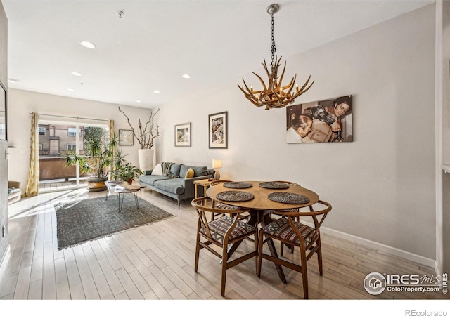 dining space with light wood-style flooring, baseboards, a chandelier, and recessed lighting