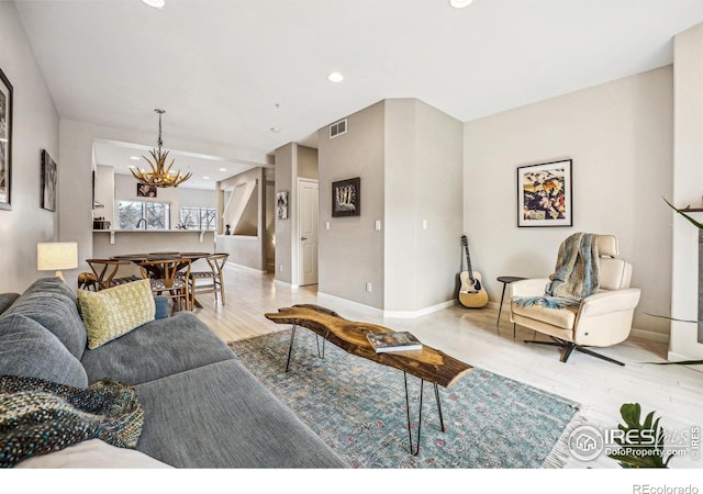 living room with light wood finished floors, baseboards, visible vents, a chandelier, and recessed lighting