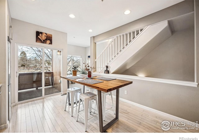 dining room with recessed lighting, light wood-style flooring, and baseboards