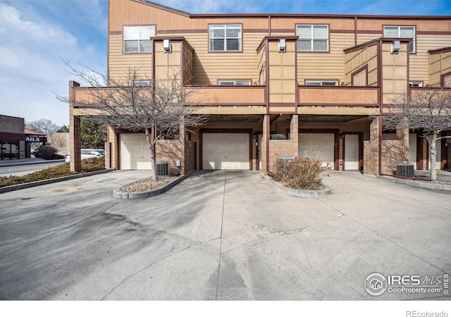 view of front of house with an attached garage, driveway, and central AC