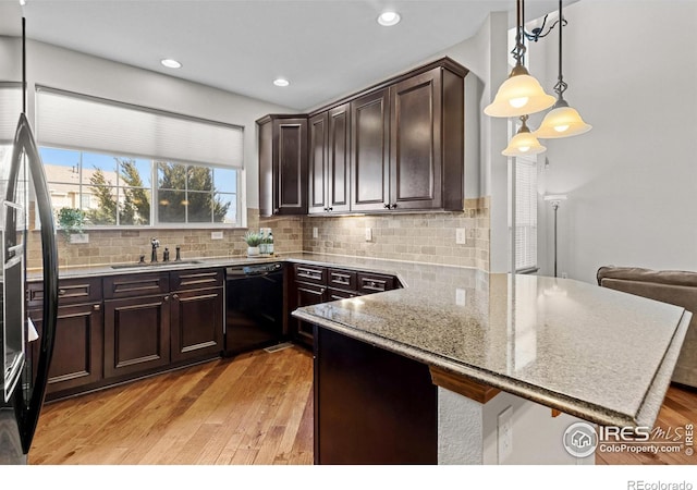 kitchen featuring dishwasher, light wood-style flooring, a sink, and dark brown cabinets