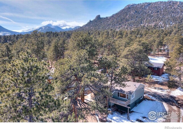 drone / aerial view with a wooded view and a mountain view