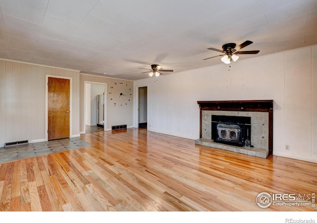 unfurnished living room featuring a ceiling fan, visible vents, and wood finished floors