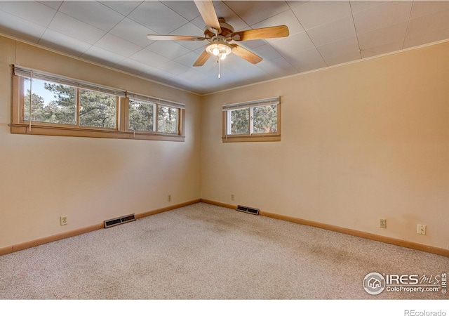 spare room with baseboards, visible vents, and carpet flooring