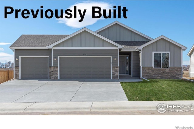 craftsman inspired home featuring a garage, concrete driveway, a shingled roof, and a front lawn