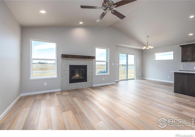 unfurnished living room featuring light wood-style floors, a tile fireplace, and baseboards