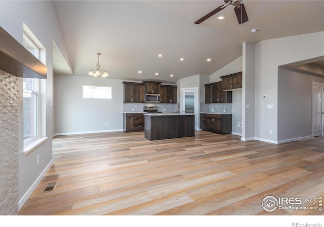 kitchen featuring dark brown cabinetry, light wood finished floors, visible vents, open floor plan, and stainless steel appliances