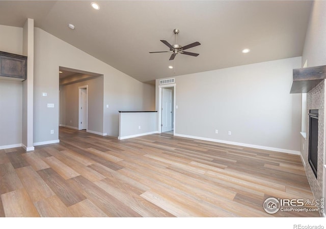 unfurnished living room with light wood finished floors, visible vents, and a tiled fireplace