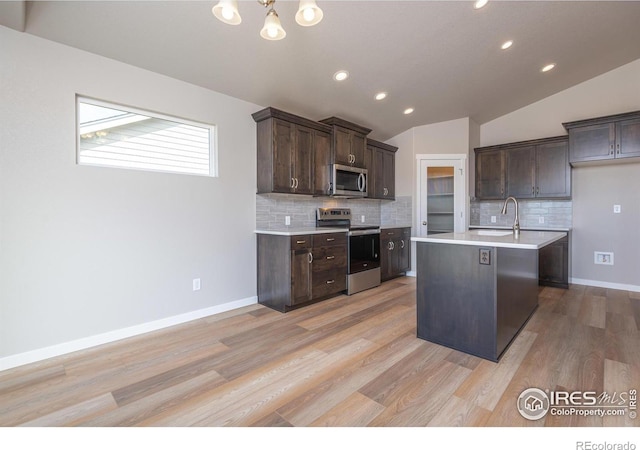 kitchen with stainless steel appliances, light countertops, vaulted ceiling, and dark brown cabinets