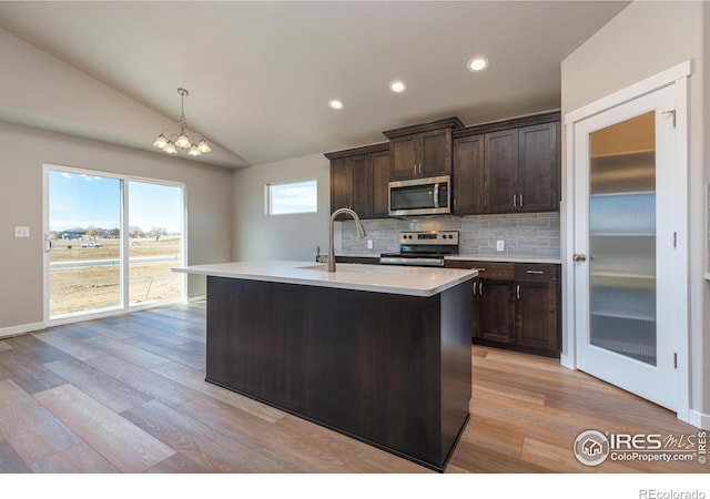 kitchen with tasteful backsplash, light countertops, appliances with stainless steel finishes, vaulted ceiling, and dark brown cabinetry