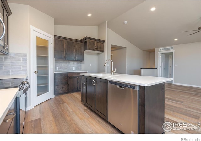 kitchen with stainless steel appliances, light wood finished floors, a sink, and dark brown cabinetry