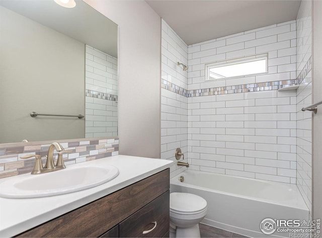 bathroom featuring toilet, vanity, and bathing tub / shower combination