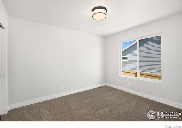 6997 Feather Reed Dr, Wellington, CO 80549 - empty room featuring dark carpet and baseboards