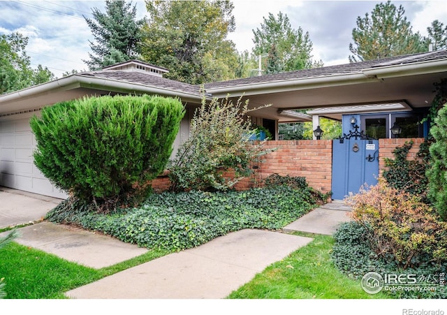 view of front facade with an attached garage, fence, and brick siding