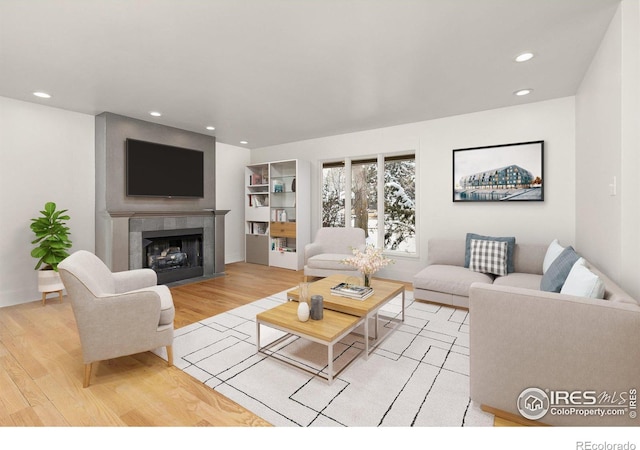 living area with a tile fireplace, light wood-style flooring, and recessed lighting