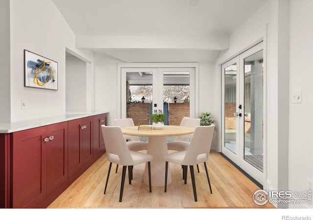 dining space with french doors and light wood-style floors