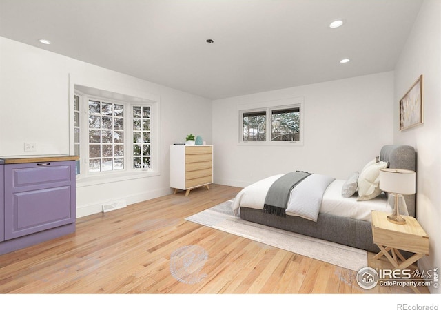 bedroom featuring recessed lighting, visible vents, light wood-style flooring, and baseboards