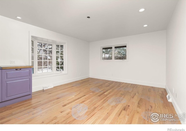 spare room with light wood finished floors, baseboards, visible vents, and recessed lighting