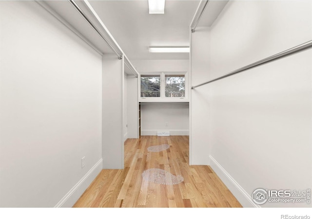 spacious closet with wood finished floors and visible vents