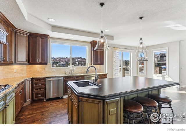 kitchen with stainless steel appliances, backsplash, dark wood finished floors, and a kitchen breakfast bar