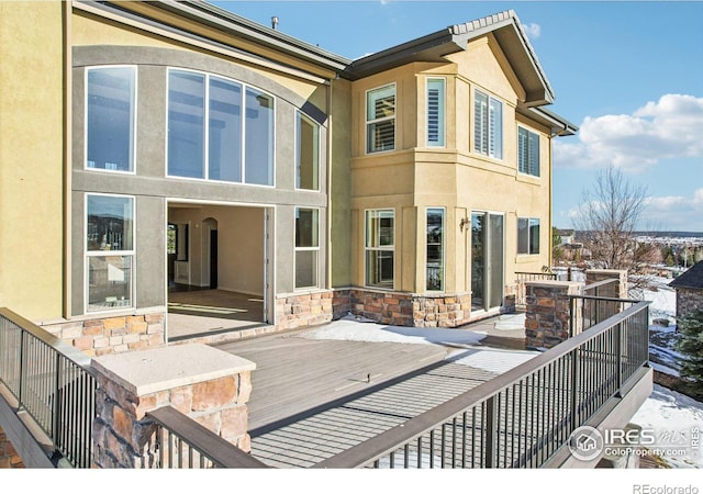 rear view of house featuring stone siding and stucco siding