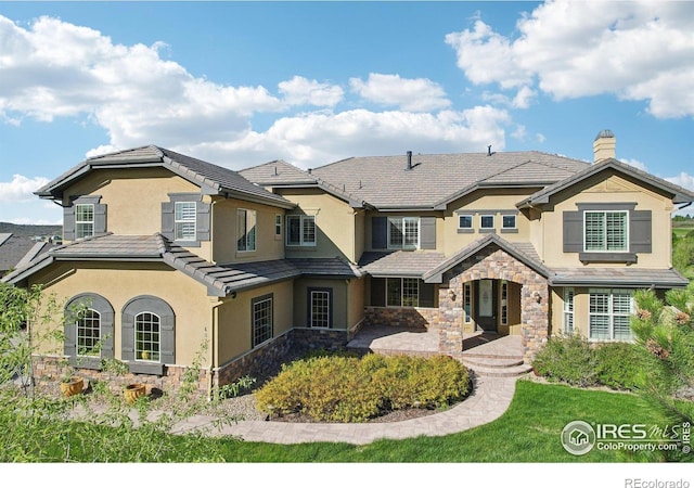 view of front facade with stucco siding and stone siding