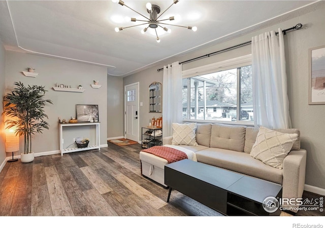 living area with a notable chandelier, baseboards, and wood finished floors