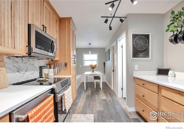 kitchen with stainless steel appliances, wood finished floors, light countertops, light brown cabinetry, and tasteful backsplash