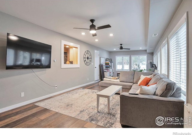 living room featuring baseboards, wood finished floors, and recessed lighting