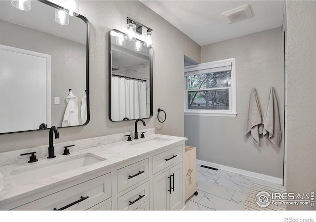 full bathroom with marble finish floor, visible vents, a sink, and baseboards