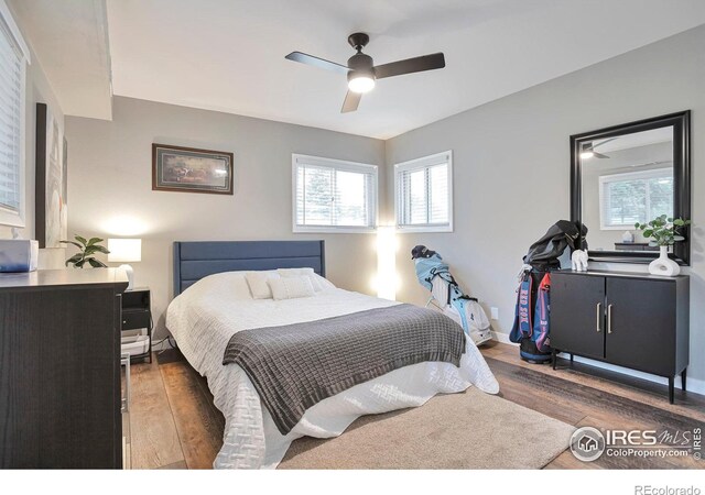 bedroom with wood finished floors, a ceiling fan, and baseboards