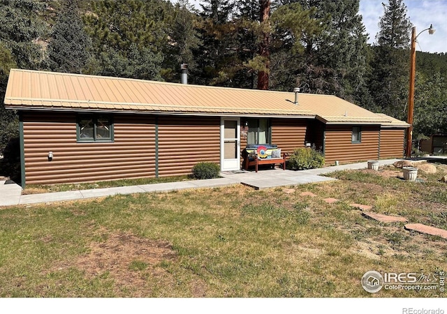 view of front of property featuring a front yard and metal roof